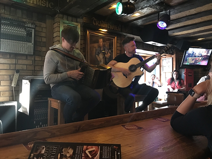 Two male guitarists performing at a restaurant